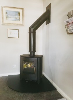 Mendip Churchill convection stove with curved slate hearth and premier twist and lock twin wall flue system coming off the top